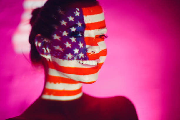 istock Young woman smiling with USA flag on her face 1273263452