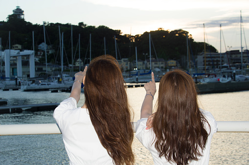 Two women watching the sunset at the yacht harbor