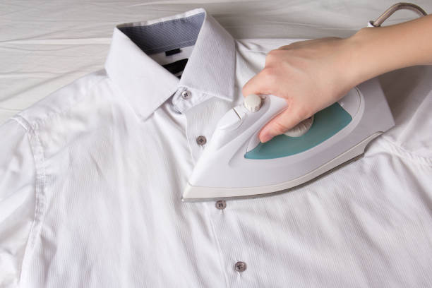 istock iron in female hand ironing cotton shirt 1273268105