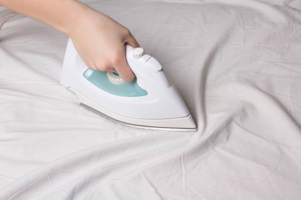 istock iron in female hand ironing cotton linen 1273268107