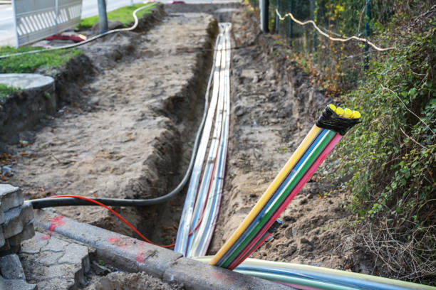 cantiere per l'installazione di cavi in fibra ottica sotto terra accanto a una strada per portare internet veloce a tutti i residenti, messa a fuoco selezionata - fiber optical network foto e immagini stock