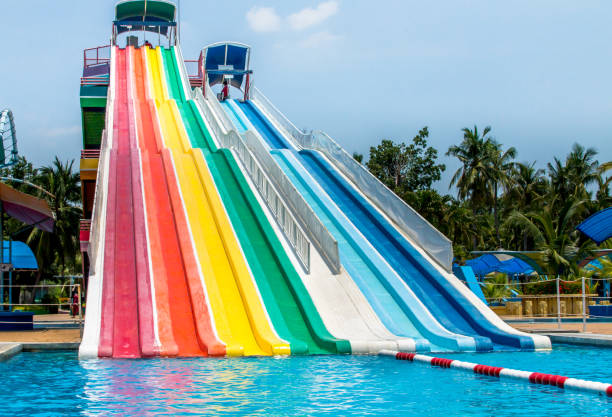красочный водяной слайдер в аквапарке - water park inflatable ring water swimming pool стоковые фото и изображения