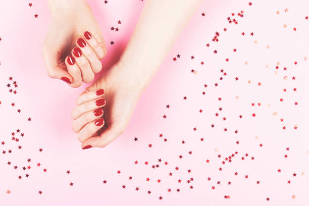 istock Two woman hands and falling confetti on pink background. 1273272104