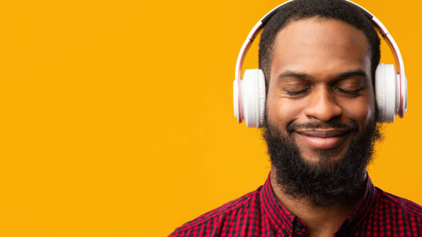 istock Smiling black man enjoying music using headphones 1273274160