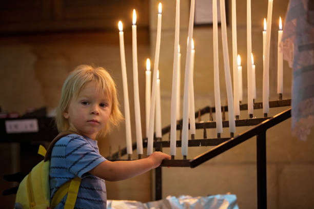 istock Little toddler boy, praying in chapel with candles in front 1273274209