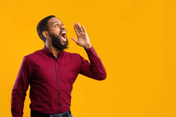 istock Black guy holding palm near mouth, screaming aside at copyspace 1273274240