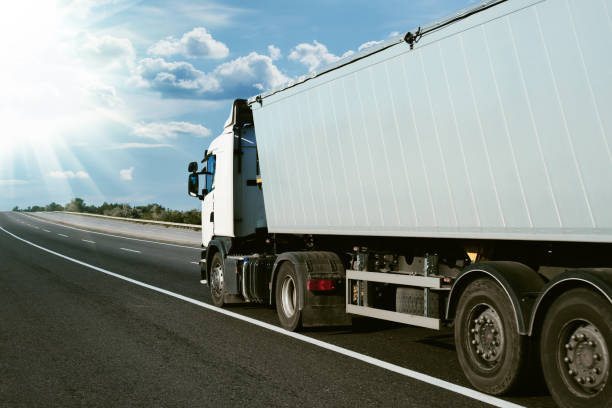 istock truck is on the road, side view, empty space on a white container - concept of cargo transportation, trucking industry 1273274455
