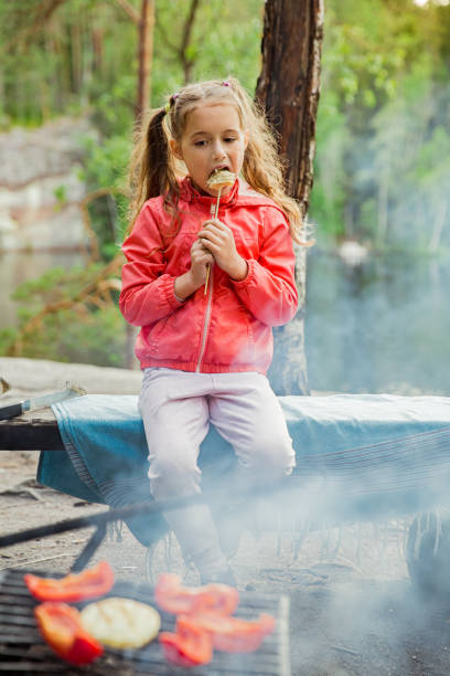istock Man and his little daughter having barbecue in forest 1273274742
