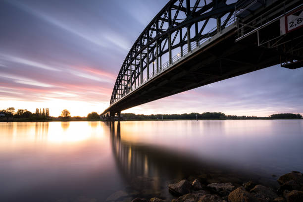 istock Striking arch bridge spans the river during the sunrise 1273274775