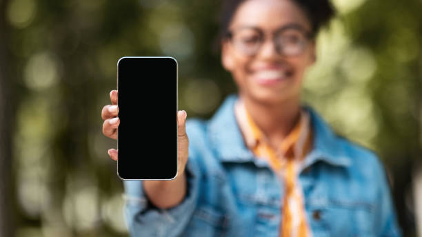 istock African Student Girl Showing Smartphone Screen Standing In Park, Panorama 1273274829
