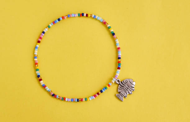 istock Handmade beadwork, beading as a hobby. Decorations made with your own hands on the background of various flowers 1273275890