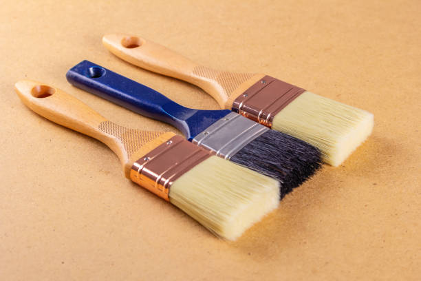 istock Brushes with wooden handles on a fiberboard. Copy space 1273275958