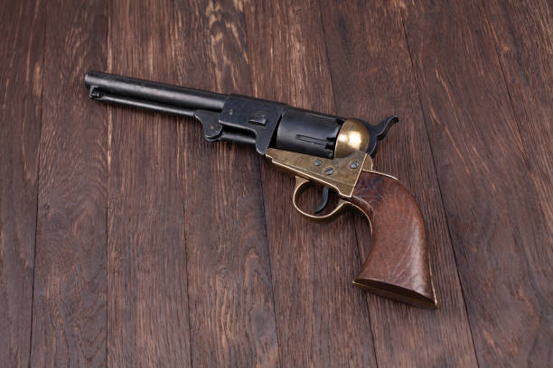 Firearms of the Old West - Percussion Army Revolver Firearms of the Old West - Percussion Army Revolver on wooden table old guns stock pictures, royalty-free photos & images
