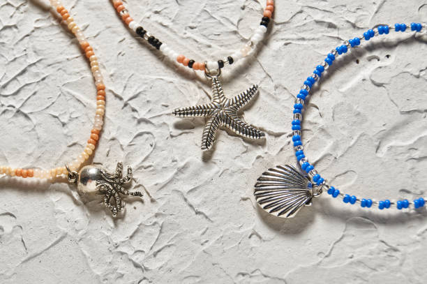Handmade beadwork, beading as a hobby. Decorations made with your own hands on the background of various flowers and plants.