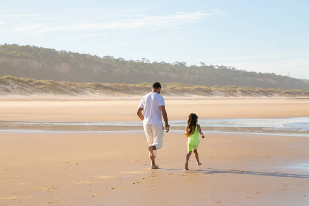 istock Back view of handsome young dad and active little girl 1273277495