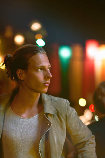 istock Handsome man lit by neon lights at night. 1273277638