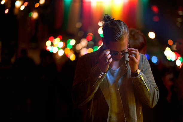 istock Handsome man wearing sunglasses lit by neon lights at night. 1273277710
