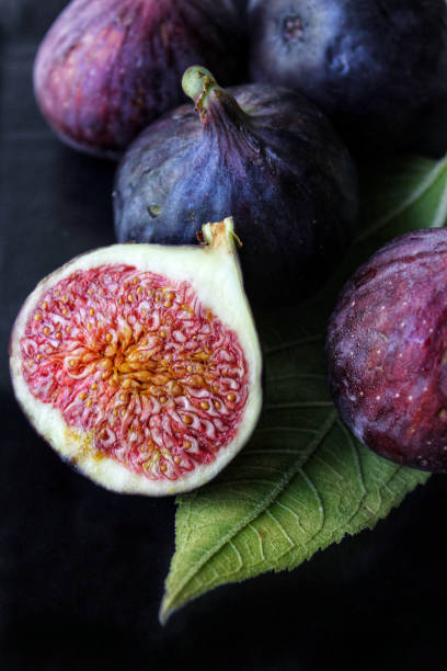 istock A slice of ripe figs with a green leaf on a dark background close-up 1273277739