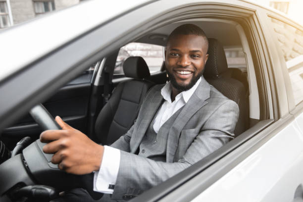 istock Handsome smiling black businessman driving luxury car 1273277916