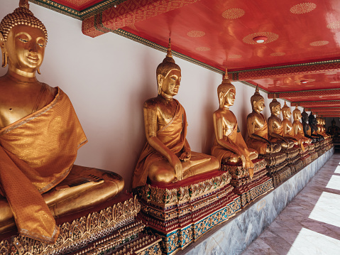 Golden buddha statues inside shrine in Thai temple