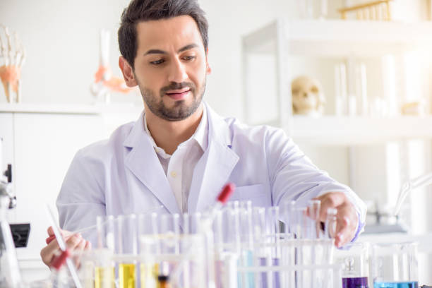 istock Attractive happiness scientist man lab technician assistant analyzing sample in test tube at laboratory. Medical, pharmaceutical and scientific research and development concept. 1273279158