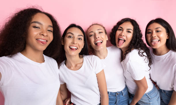 istock Multicultural Ladies Making Group Selfie Showing Tongues Over Pink Background 1273281657