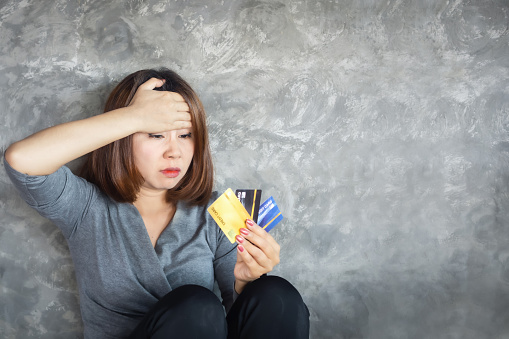 Asian woman hand holding credit cards having problem with overspending and debt