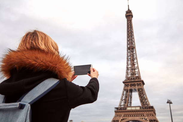 istock Girl using cellphone with Paris city background and Eiffel tower. 1273283953