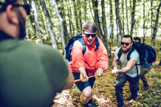 istock Hikers Helping Each Other With Ropes In Forest 1273284961