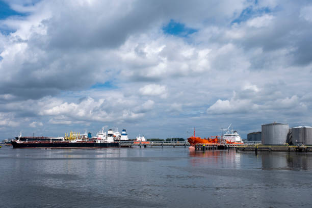 tanker and oil storage tanks in rotterdam, netherlands. the port is the largest in europe and facilitate the needs of a hinterland - petrolium tanker imagens e fotografias de stock