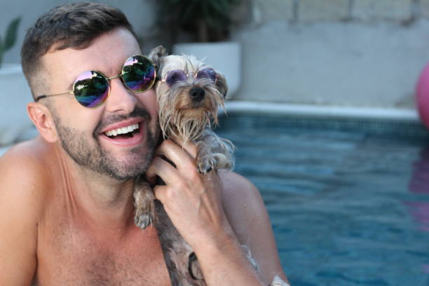 uomo con il suo cane in piscina - underwater dog adult happiness foto e immagini stock