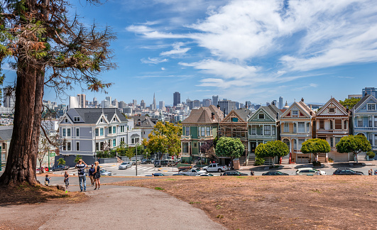 San Francisco, CA / USA - July 17 2015: Alamo Square is a residential neighborhood and park in San Francisco, CA, in the Western Addition. The Alamo Square neighborhood is characterized by Victorian architecture. A row of Victorian houses facing the park on Steiner Street, is known as the \