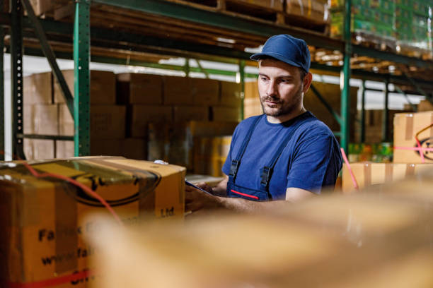 istock Manual worker checking packages before delivery in storage room. 1273286414
