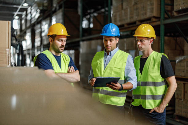 istock Manager giving instructions to his workers in distribution warehouse. 1273286749