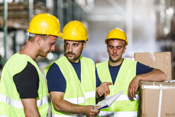 istock Group of warehouse workers talking about checklist in storage room. 1273286876