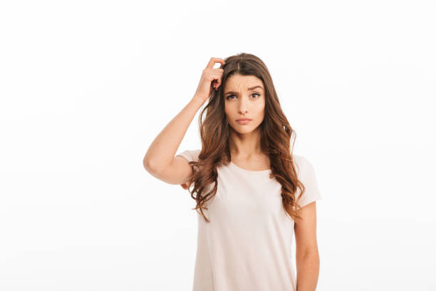 istock Thinking brunette woman in t-shirt touching head 1273287849