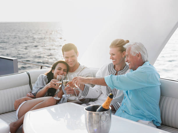 Boating adventure Two generational family celebrating with champagne on yacht yacht photos stock pictures, royalty-free photos & images