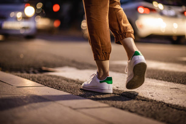 nahaufnahme menschlicher beine, die auf dem crosswalk laufen - sidewalk walking human foot city stock-fotos und bilder