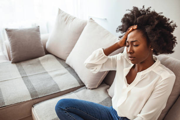 istock Woman suffering from a headache and rubbing her temples at home. 1273292570