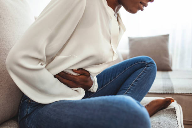 Ouch! My tummy! Cropped shot of an attractive young woman lying on her sofa alone and suffering from period cramps at home. Ouch! My tummy! Woman with menstrual pain stomach cramps stock pictures, royalty-free photos & images