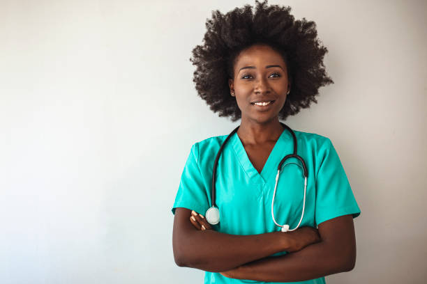 portrait of a nurse standing in a hospita - female nurse nurse scrubs female doctor imagens e fotografias de stock