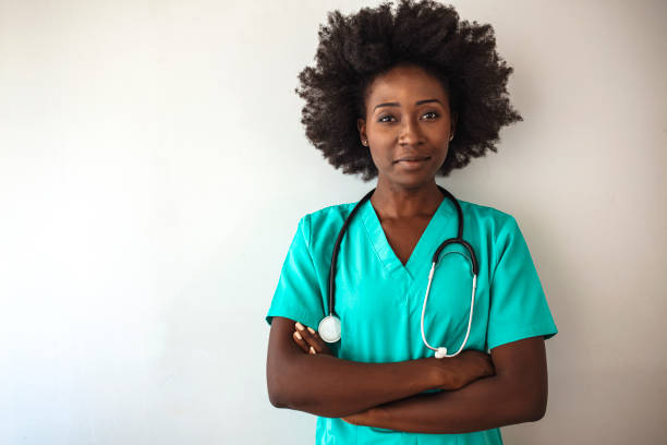 freundliche krankenschwester mit stethoskop isoliert auf grau. - female nurse nurse scrubs female doctor stock-fotos und bilder