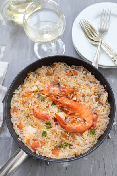 istock rice with fish and seafood in frying pan on ceramic background 1273294189
