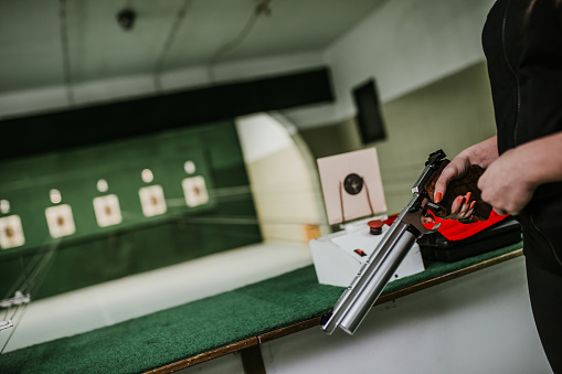 Shooting range. Young woman practicing shooting in a modern indoor shooting range.