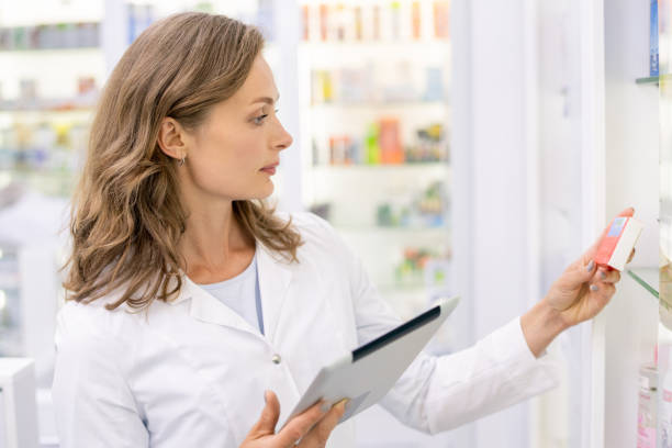 istock Young female pharmacist with tablet learning information about new medicaments 1273296442