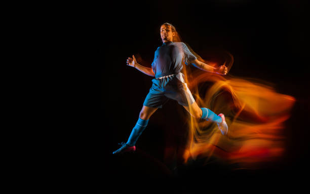 istock Football or soccer player on black background in mixed light, fire shadows 1273297826