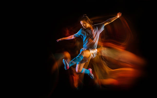 istock Football or soccer player on black background in mixed light, fire shadows 1273297830