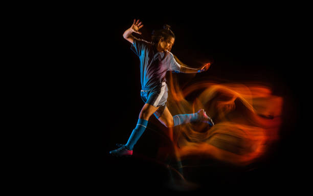 istock Football or soccer player on black background in mixed light, fire shadows 1273297833