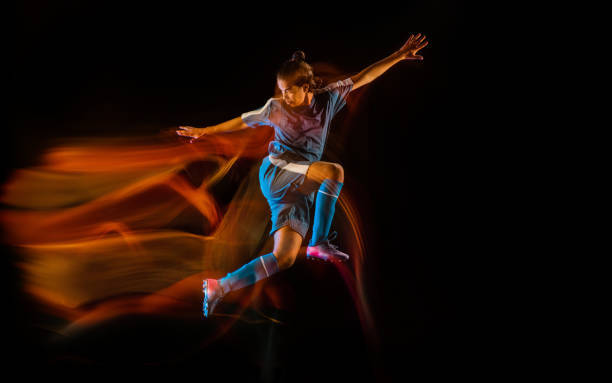 istock Football or soccer player on black background in mixed light, fire shadows 1273297835