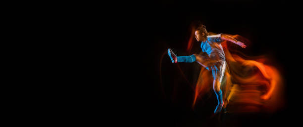 istock Football or soccer player on black background in mixed light, fire shadows 1273297837